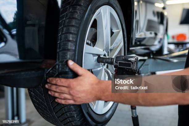 Mechanic Changes A Tire In A Repair Shop Germany Stock Photo - Download Image Now - Tire - Vehicle Part, Flat Tire, Turning