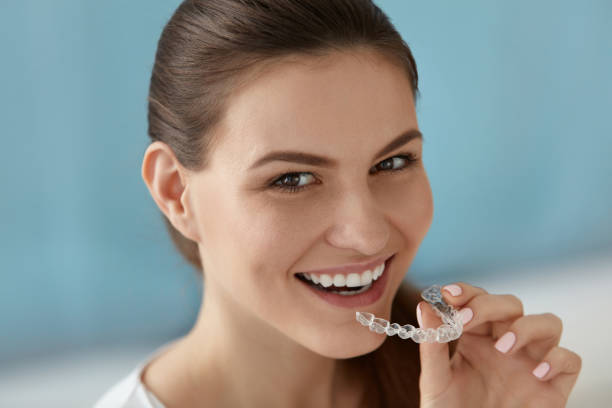 istock Dental care. Smiling woman using removable clear teeth braces 1157104696