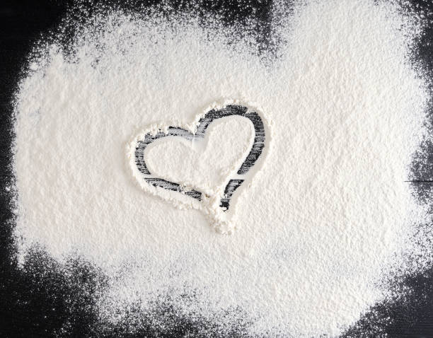 istock sprinkled white flour on the black table, top view 1157105096
