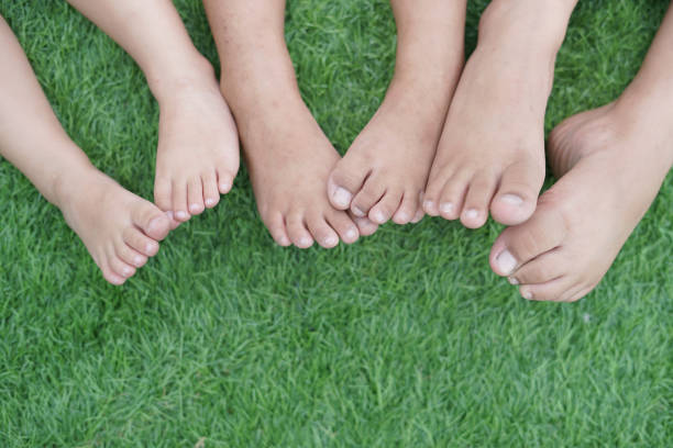 Happy Child's feet on the green grass stock photo