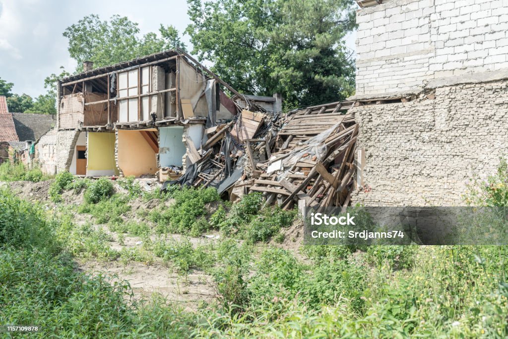 Restos de huracán o terremoto después de desastres daños en casas viejas en ruinas con techo y pared colapsados - Foto de stock de Derribado libre de derechos