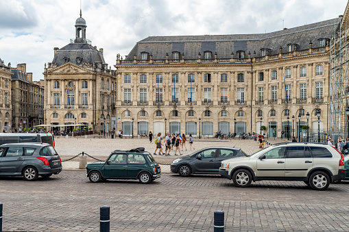 Traffic on the promenade in the centre of Bordeaux, France. In the background is the Unesco World Heritage site Stock Market buildings.