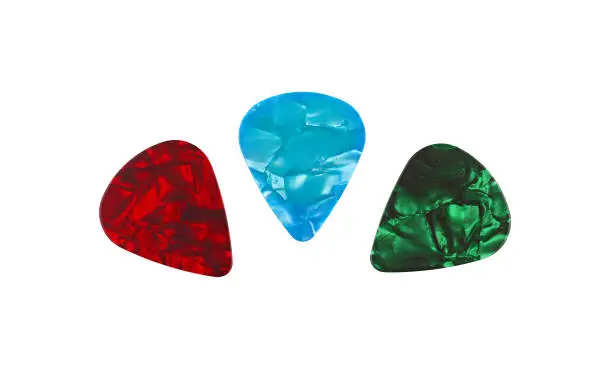 Three colorful pearl guitar plectrum picks, green, blue, red, isolated on white background