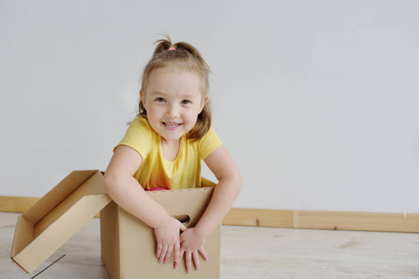istock A smiling girl sitting in big cardboard box 1157113089