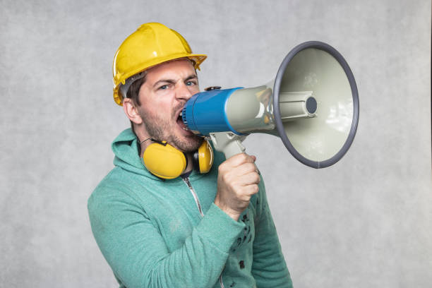 istock the construction worker holds a megaphone in his hands, the concept of issuing orders 1157115202