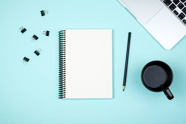 istock Minimal workplace with laptop and blank notepad on colored background. Top view. Flat lay 1157117141