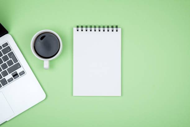 istock Minimal workplace with laptop and blank notepad on colored background. Top view. Flat lay 1157117148