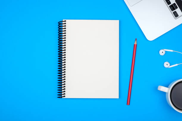 istock Minimal workplace with laptop and blank notepad on colored background. Top view. Flat lay 1157117330