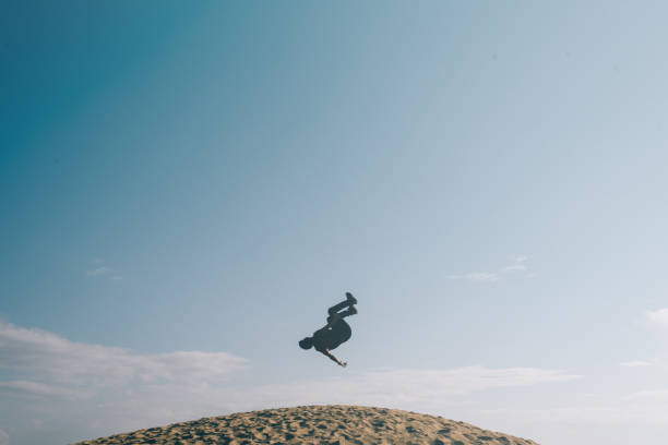 istock Low Angle View Of Man Jumping On Hill Against Sky 1157117804