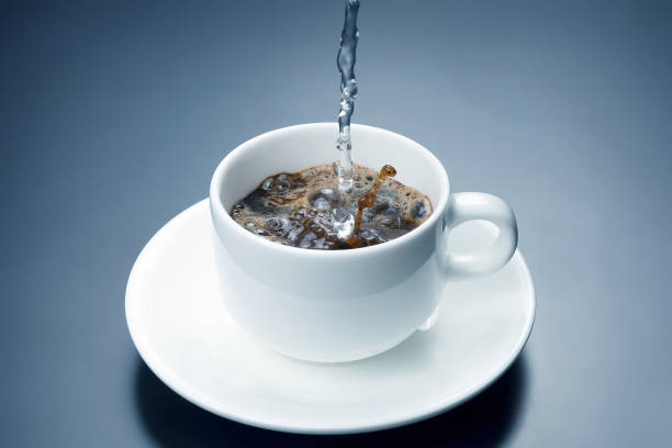 istock boiled water from the kettle is poured into a white Cup for coffee 1157121398