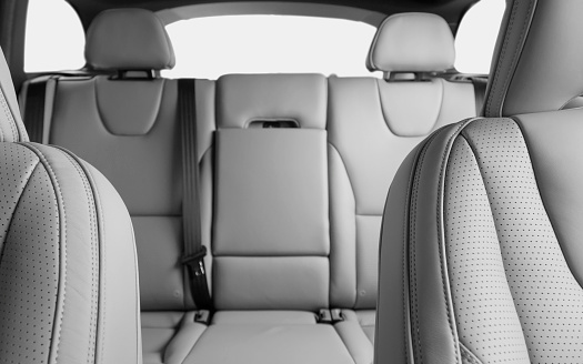 Back passenger seats in modern luxury car, frontal view, white perforated leather, car interior concept