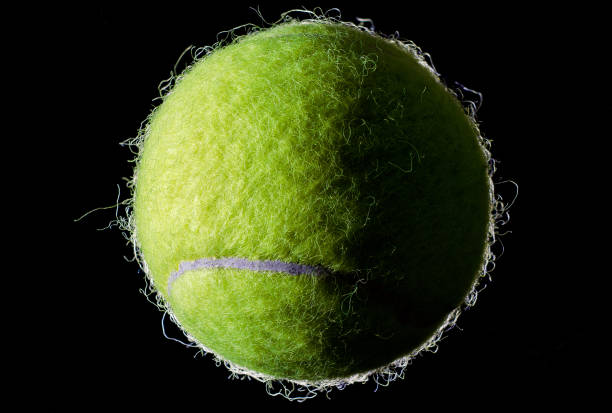 istock Tennis ball on black background 1157122699