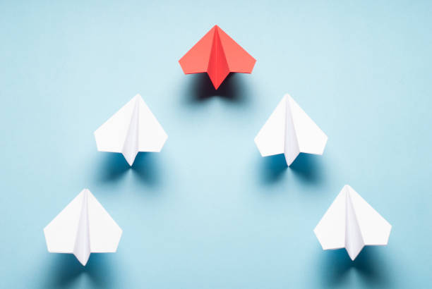 istock Red plane and white plane on blue background. Red and white origami planes. Minimalist composition with paper planes. 1157124214