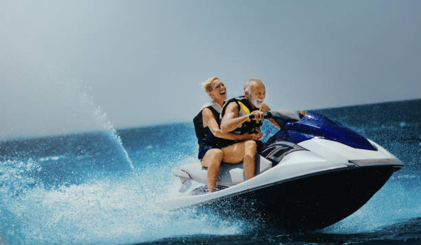 Young at heart. Senior couple enjoying jet skiing on their summer vacation. jet boat stock pictures, royalty-free photos & images