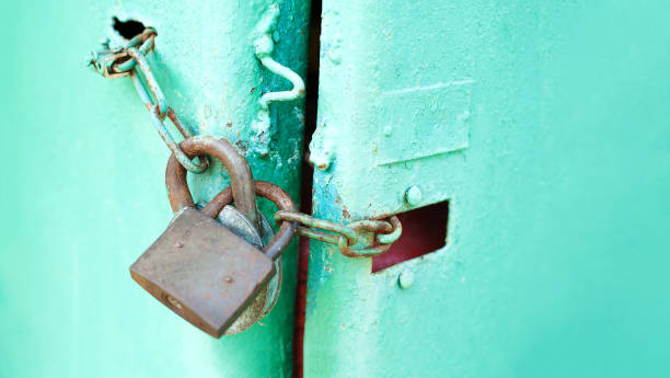 istock Metal door with Two old rusty padlock. Copy space. Security and protection conception 1157125063