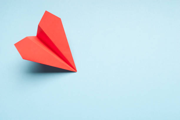istock Red paper plane on blue. Origami plane on blue background. 1157125249