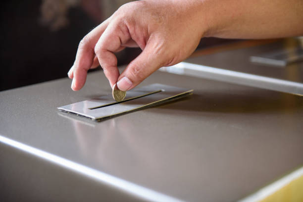 istock Man hand donating money into charity box 1157126518