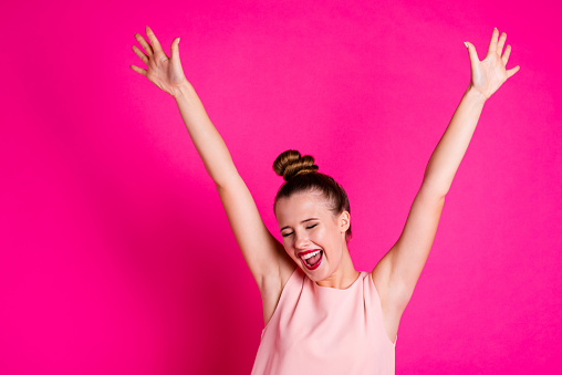 Close up photo of cute lovely charming people person raise hands close eyes, ecstatic thrilled cheerful enjoy free time wear pastel-colored clothes top-knot isolated pink bright background