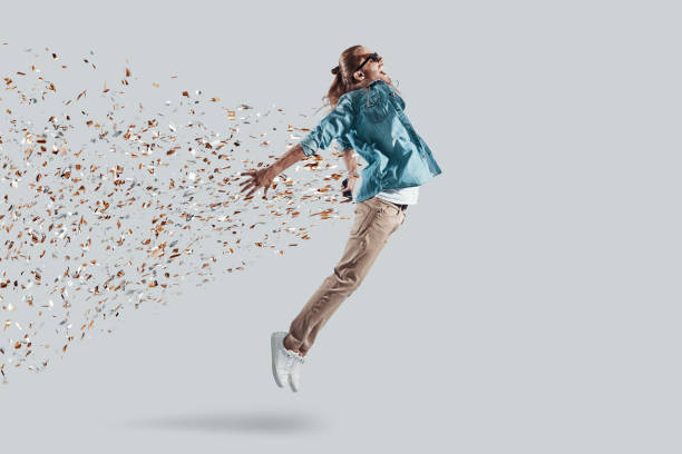 Freedom! Full length of handsome young man keeping arms outstretched while hovering against grey background