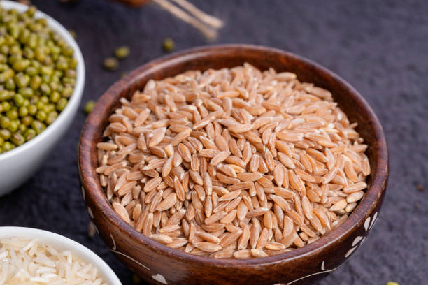 коричневый рис в миске - brown rice фотографии стоковые фото и изображения