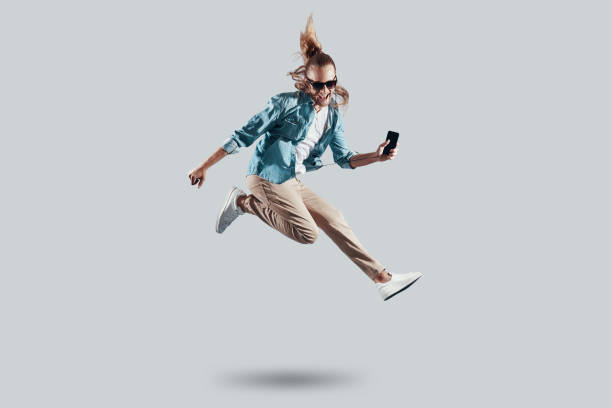 istock Hey! Full length of handsome young man hovering against grey background 1157128426