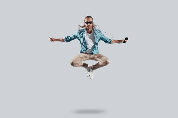istock Insanity. Full length of handsome young man keeping arms outstretched while hovering against grey background 1157128565