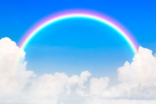 Blue sky and white cloud and rainbow. A bright rainbow background.