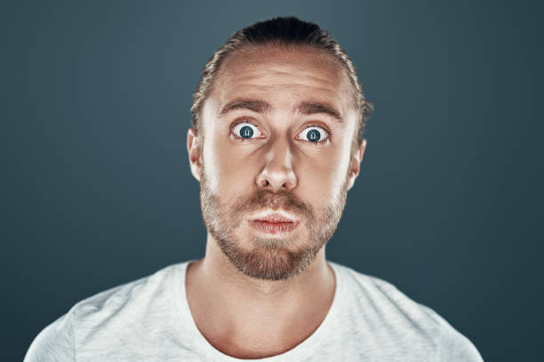 istock Real surprise. Shocked young man looking at camera and making a face while standing against grey background 1157129901