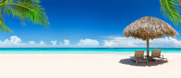 istock Beach chairs with umbrella and beautiful sand beach. 1157131059