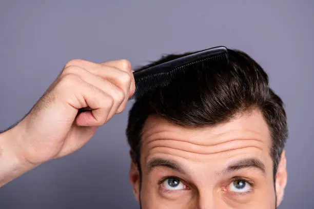 Cropped close up photo amazing he him his macho hands arms plastic hair styling brush take care hairdo, barber shop stylist visit look up process experiment wear white t-shirt isolated grey background