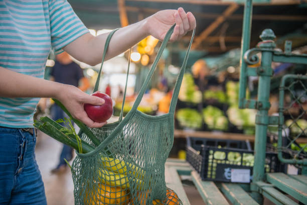 fruits et légumes dans un sac réutilisable en maille de coton, zero waste shopping sur le marché extérieur - production locale photos et images de collection