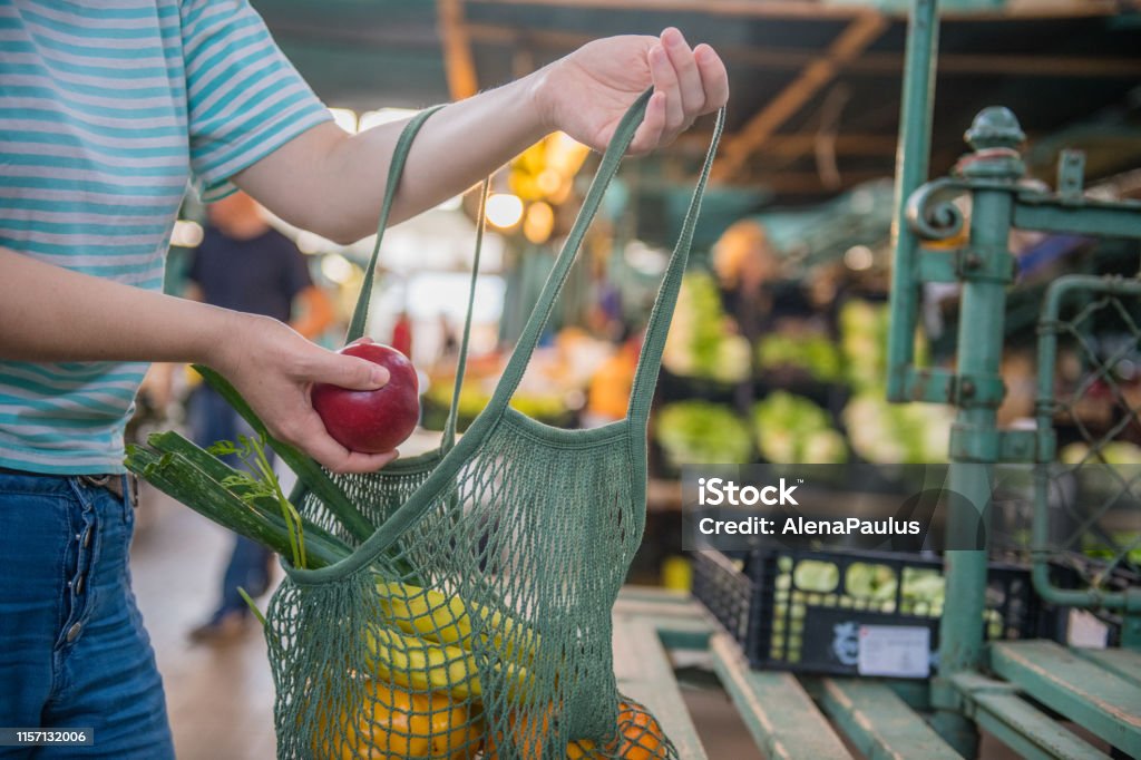 Fruits and Vegetables in a cotton mesh reusable bag, Zero Waste Shopping on Outdoors Market Fruits and Vegetables in a cotton mesh reusable bag, Zero Waste Shopping concept at public outdoors market. Shopping Stock Photo