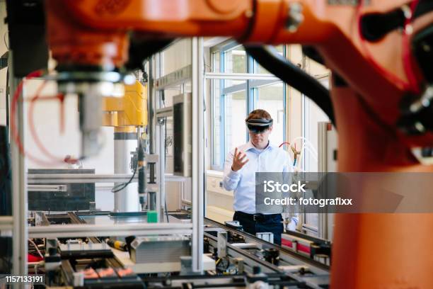 Engineer Works With A Hololens Place A Virtual Robotic Arm Into The Production Line Stock Photo - Download Image Now