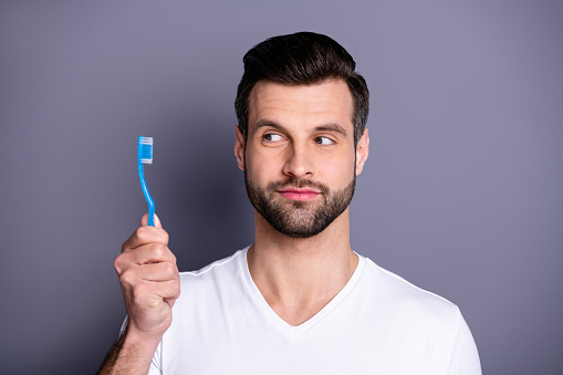 Close up photo amazing he him his macho perfect ideal appearance advising, buy buyer hand arm novelty plastic personal equipment tooth brush toilet wear casual white t-shirt isolated grey background