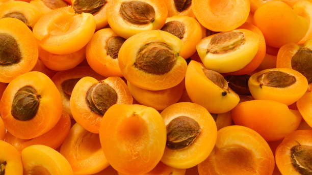 istock Ripe juicy orange apricots slices fruit background. 1157133806