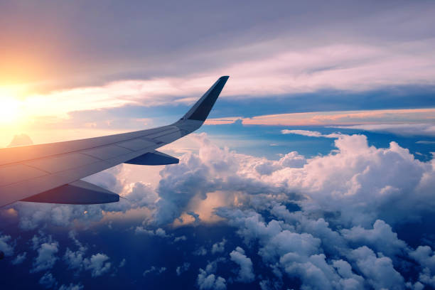 primer plano del ala del avión volando al amanecer - ala de avión fotografías e imágenes de stock