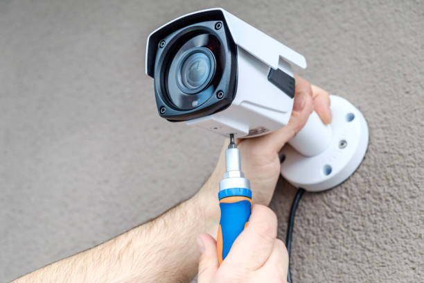 istock Close-up hands of technician adjusting CCTV camera on wall 1157139036