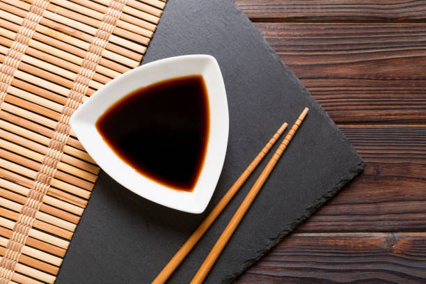 Chopsticks and soy sauce on black stone plate, wooden background with copy space Chopsticks and soy sauce on black stone plate, wooden background with copy space. soy sauce photos stock pictures, royalty-free photos & images