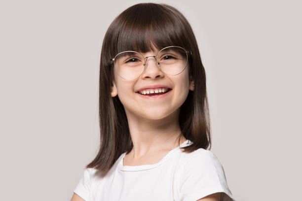 lustiges kleines mädchen trägt brille mit runden großen spektakel rahmen - child glasses eyewear little girls stock-fotos und bilder