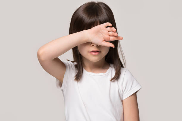 istock Little girl touch forehead with hand feeling unhealthy studio shot 1157139753