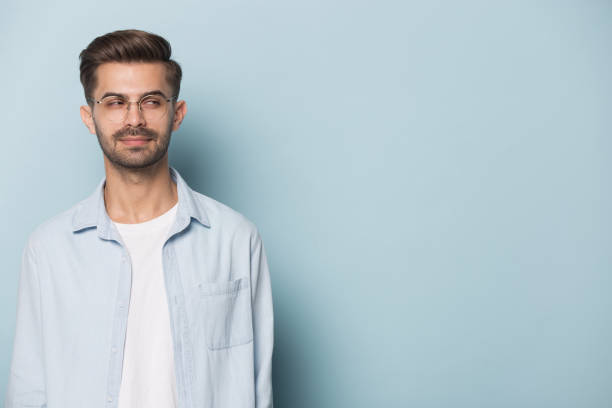 istock Sly guy looking aside at copyspace isolated on blue background 1157139817