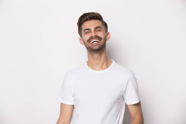 istock Laughing guy wearing white t-shirt posing on studio background 1157139827