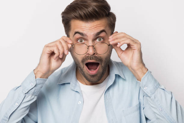 istock Shocked guy lowering glasses looking at camera studio shot 1157139831
