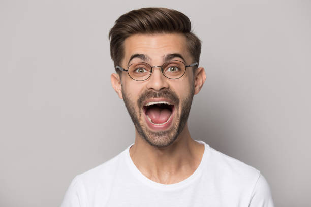 istock Headshot portrait funny guy wearing glasses screaming posing in studio 1157140346