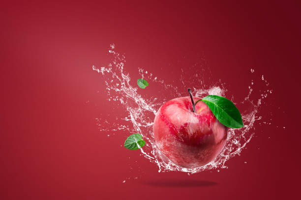istock Water splashing on Fresh Red apple on red background 1157140717