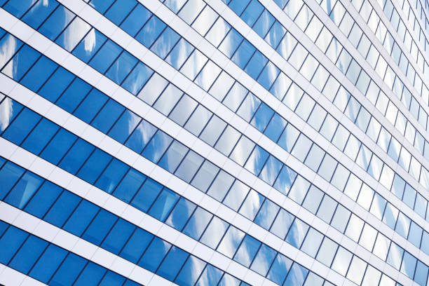 istock Glass mirror skyscraper wall with blue sky and white clouds reflection close up, modern business center view, financial city district, commercial downtown design, geometric texture pattern, copy space 1157142375