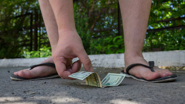 um homem novo encontrou o dinheiro na estrada e pegarou dólares - twenty dollar bill human hand paper currency number 20 - fotografias e filmes do acervo