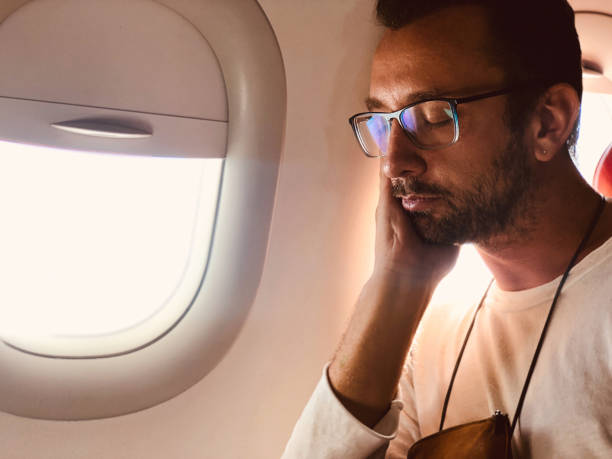 istock Tired / sick passenger in a modern airplane seat next to the window. 1157145240