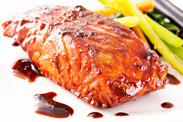 Fish cooked in teriyaki sauce with vegetables on the side stock photo