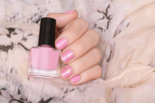 istock Female hand with pink and glitter nail design 1157156316